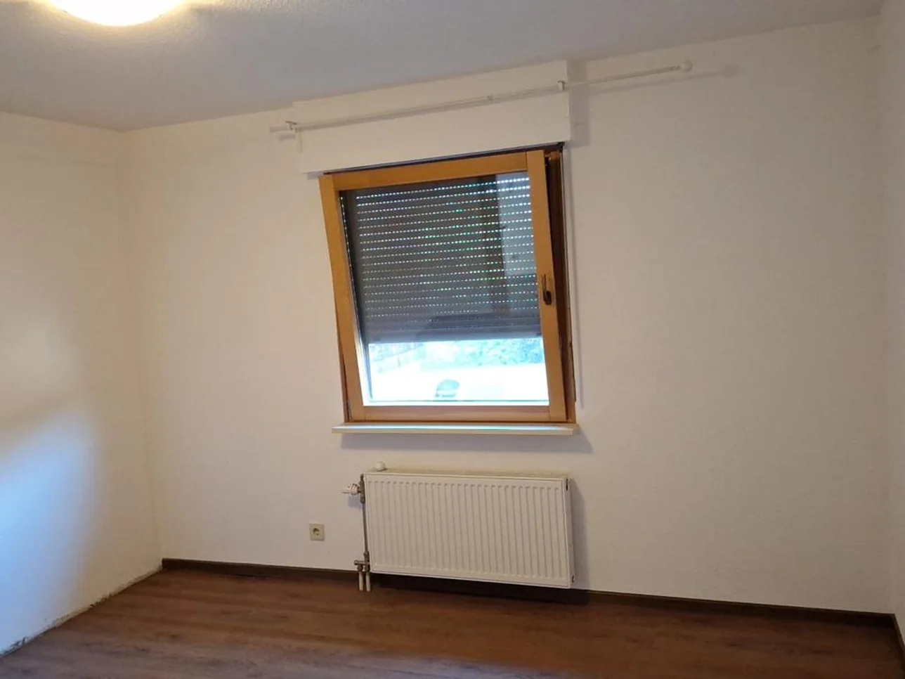 Nachher: fertig gestrichenes Zimmer mit sauberem Holzboden